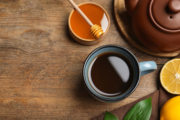 Tea with honey and lemon on wooden table, flat lay. Space for text