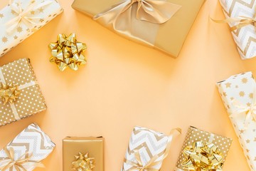 Holiday background in gold colors, gift boxes with bows on a gold background, flat lay, top view, copy space