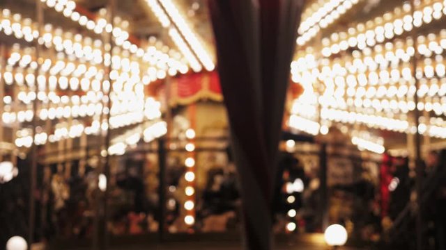 Bright carousel with lights and horses rolls the children. Christmas background.