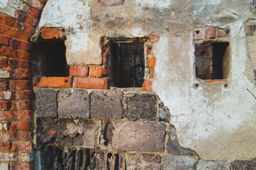Windows in red brick wall of old ruined building