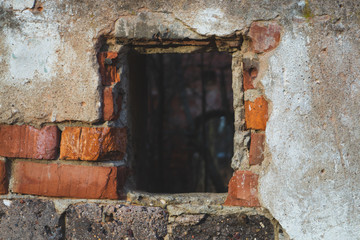 Window in red brick wall of old ruined building
