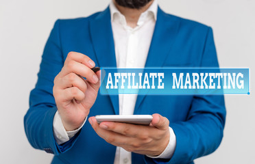 Writing note showing Affiliate Marketing. Business concept for compensation to thirdparty publishers to generate leads Businessman in the blue suite with lap top pointing with finger
