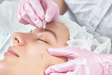 Facial skin reinforcement in office of professional cosmetologist, facelift with mesothreads,...