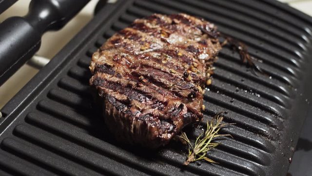 Juicy chuck eye roll steak, a large piece of marinated grilled meat. 