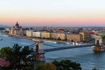 Aerial landscape view of Budapest. Picturesque view of Chain Bridge over Danube River and The Hungarian Parliament Building in the background. Scenic autumn sunset colors. Budapest, Hungary