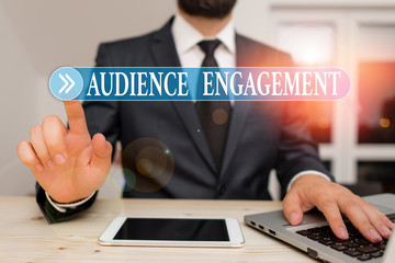 Writing note showing Audience Engagement. Business concept for active involvement of an audience in a live broadcast Male human wear formal clothes present use hitech smartphone