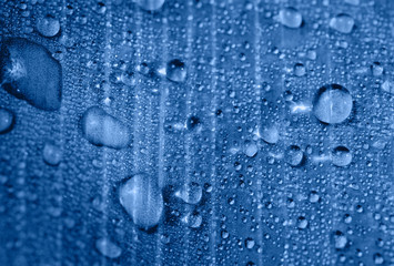 Drops of transparent rain water on a leaf close up. Beautiful nature macro background. Focus is on some water drops.