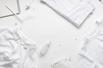 White monochromatic flatlay on white background. Clothes, accessories, stationery and beauty...