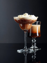 Coffee cocktails on black reflective background.
