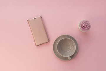 Mobile phone and candle on a pink background