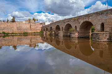View of the Roman bridge of Merida with its reflection on the Guadiana river. Merida. Spain.The...