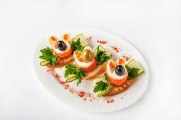 Seafood rolls in a restaurant close-up. Salmon rolls with cheese and olive on toast on a white plate and copy space.
