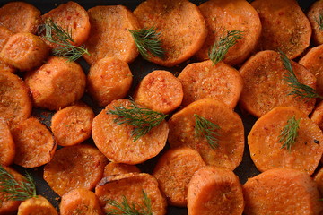 Healthy homemade baked orange sweet potato slices with herbs. Vegan food