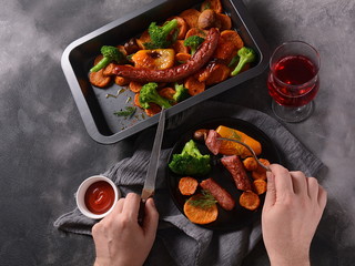 Homemade baked orange sweet potato slices with sweet yellow bell pepper, broccoli, Bavarian sausage and ketchup. Tasty dinner