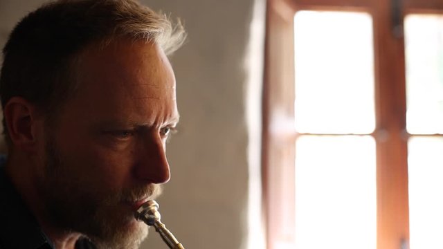Hombre de mediana edad de pelo rubio tocando la trompeta