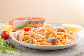 Semolina pasta with salmon and salmon steak on a white wooden background. Side view, selective focus.