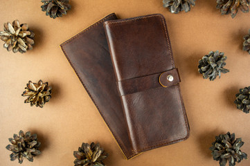 wallet made of genuine leather on the table in the process of packing a gift on a brown background