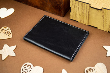 wallet made of genuine leather on the table in the process of packing a gift on a brown background