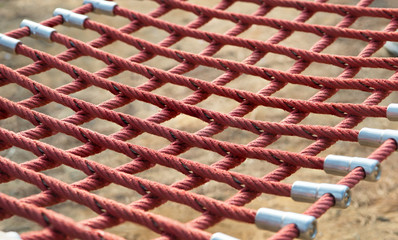 Red rope knotted of hammock in park.