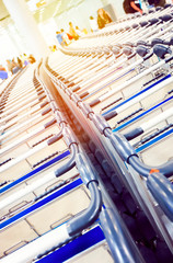 Rows of baggage trolleys in the building of the airport in retro style