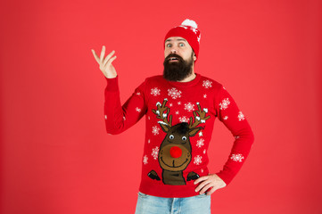 Fototapeta na wymiar Need inspiration. New year concept. Join winter holiday party. Christmas Party. Winter outfit. Hipster emotional bearded man wear winter sweater and hat red background. Consequence. What to do