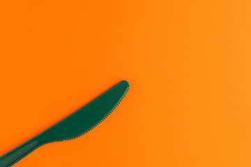 Plastic Knife Isolated On Orange Background, Green Plastic Knife