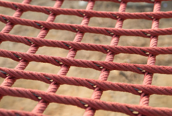 Red rope knotted of hammock in park.