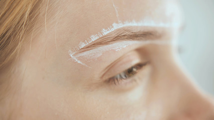 Create permanent eyebrow makeup. Marking the shape of the eyebrows.