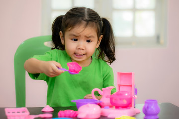 Kindergarten children in Asia are playing toys on the table.