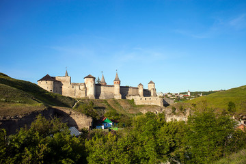 Naklejka premium Summer landscape with green fields, antique fortress Kamianets-Podilskyi in Ukraine