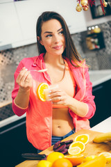 Healthy eating woman on diet drinking fresh juice, smiling girl with fruits and weight loss drinks at kitchen.