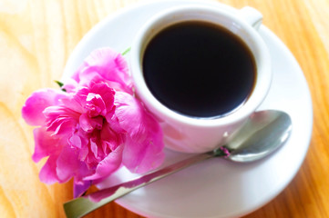 cup of coffee and flowers on wooden background