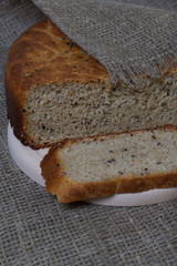 Freshly baked bread. A loaf of bread is cut and lies on a cutting board. The surface is covered with linen.