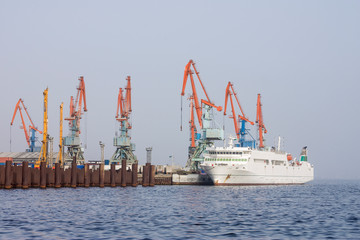 Fototapeta premium Panorama of the sea port. At the pier there is a ship for loading and unloading cargo and for receiving passengers.