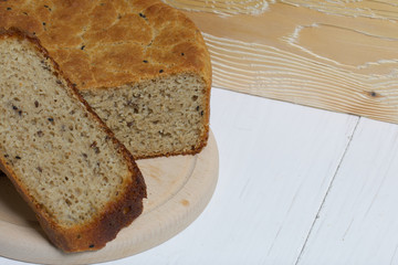 Freshly baked bread. A loaf of bread is cut and lies on a cutting board. Near a piece of linen...