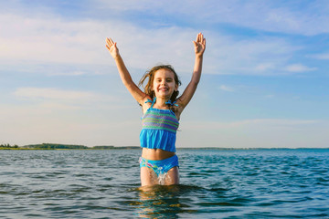 happy little girl kid rest on the sea. Smiling girl swimming in a circle in the sea