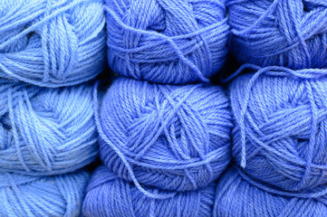 background of rows skeins of fluffy wool yarn for knitting different blue colors