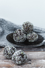rum chocolate balls with coconut flakes on tray. Sweet raw vegan balls. Chocolate, coconut, dates and banana. Wooden background. Healthy lifestyle. 