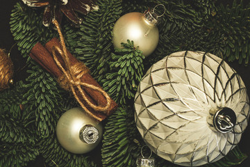 Close-up art installation for New Year or Christmas from spruce twigs, glass balls, cord balls, pine cone and cinnamon sticks.