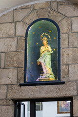 Statue of Virgin Mary stands in a niche at the entrance to the Saint saviour monastry near to the gate New Gate in the Old City in Jerusalem, Israel