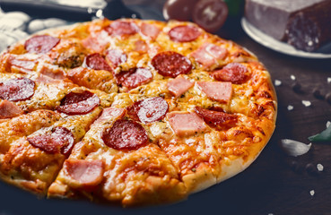 Pepperoni Pizza with Mozzarella cheese, salami, ham, Spices. Italian pizza on wooden table background