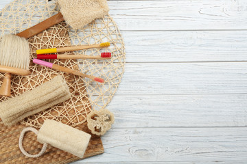 Flat lay composition with bamboo toothbrushes on white wooden table. Space for text