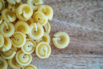 Close up view on authentic Italian pasta shapes on wooden background 