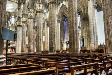 Obraz premium Interiors of building with columns and benches of the Milan Cathedral (Duomo di Milano), the cathedral church of Milan, Lombardy, Italy. Dedicated to the Nativity of St Mary.