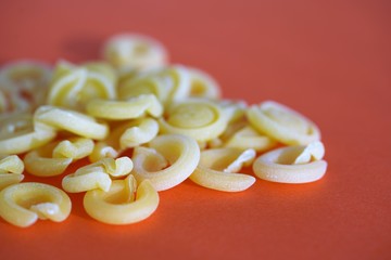Close up view on selection of authentic Italian messicani pasta on red surface