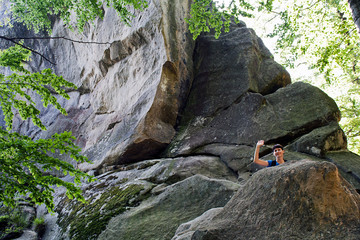 beautiful girl tourist with a backpack on a cliff, mountains, rocks Dovbush, Ukraine