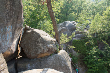 Obraz premium beautiful girl tourist with a backpack on a cliff, mountains, rocks Dovbush, Ukraine