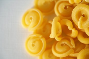 Top view on Italian messicani pasta shapes on white background