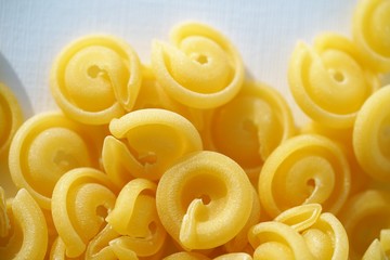 Top view on Italian messicani pasta shapes on white background