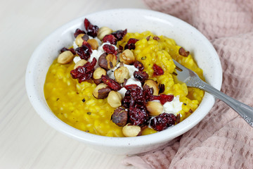 pumpkin risotto with cheese dried cranberry nuts on a light background